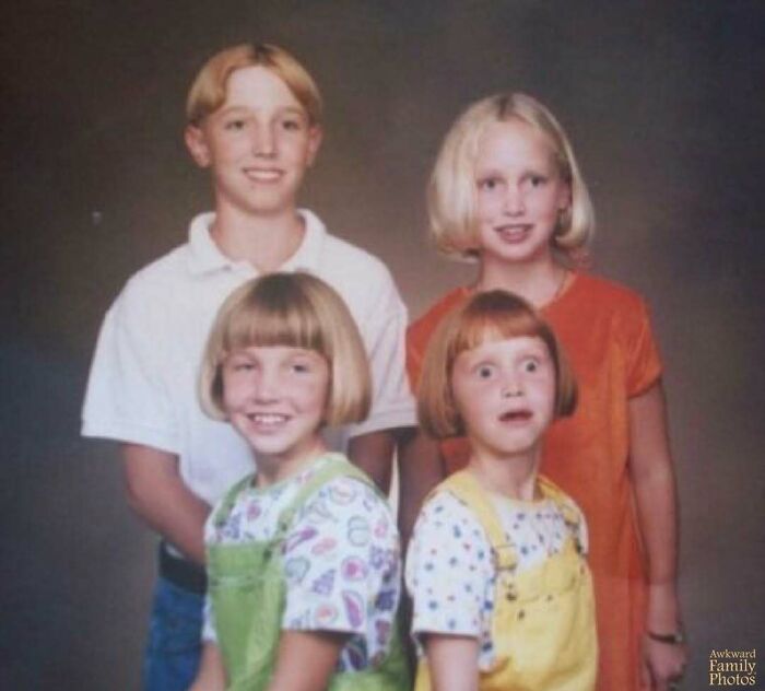 Four children posing for an awkward family photo with unique expressions and trendy 90s hairstyles.