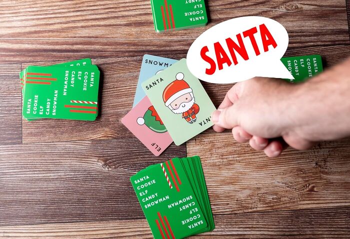 Hand holding a Santa card during a festive matching game, showcasing fun indoor activities to keep kids entertained.