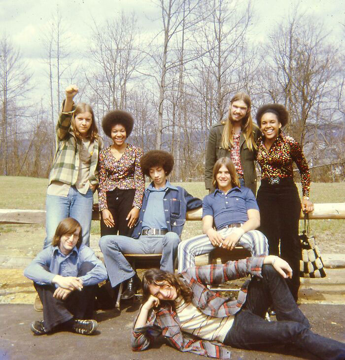 Students in '70s high school fashion posing outdoors, showcasing denim and plaid styles typical of the era.