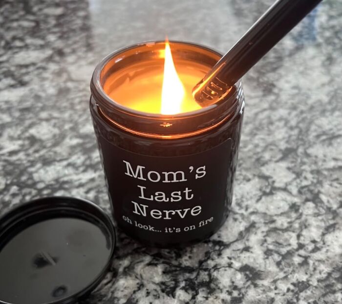 Candle labeled Mom's Last Nerve lit on granite countertop, a perfect Christmas gift making moms cry happy tears.