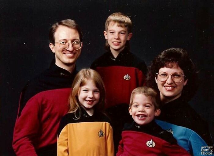 Awkward family photo with five members wearing Star Trek uniforms, smiling in a studio portrait.