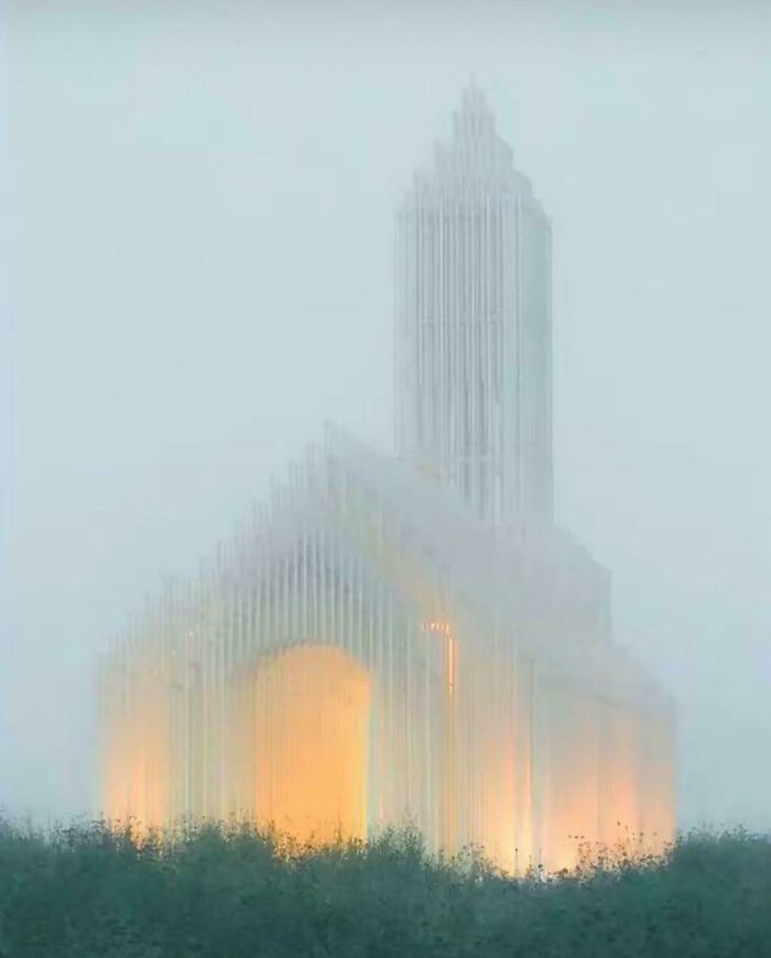 Mysterious building with glowing orange light in fog, exuding an evil aura like a supervillain headquarters.