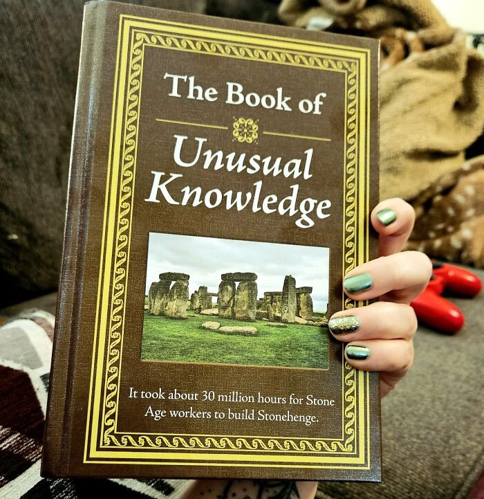 The Book of Unusual Knowledge, a unique white elephant present held by a person with painted nails.