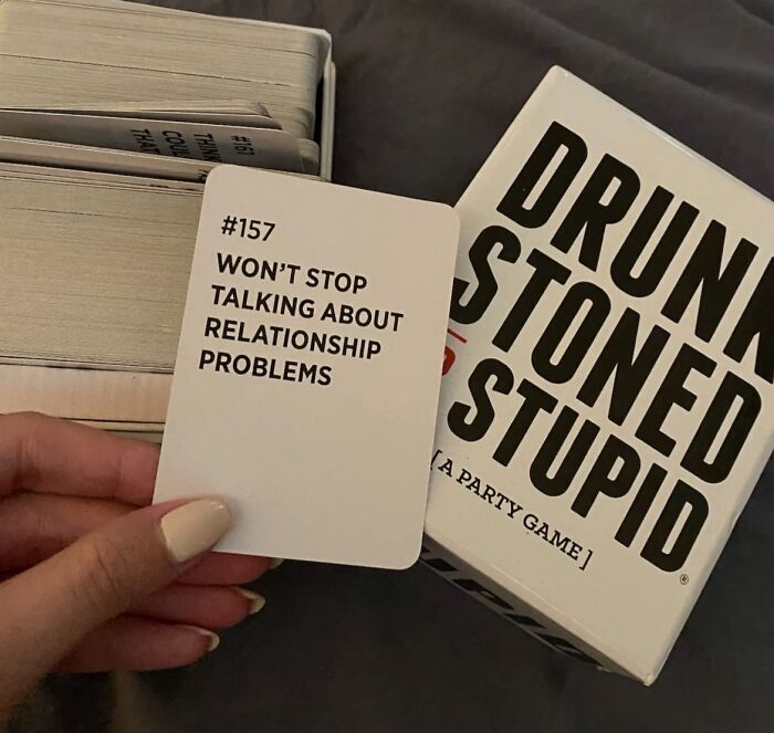Hand holding a card from Drunk S****d Stupid party game, a popular white elephant present idea for gift exchanges.