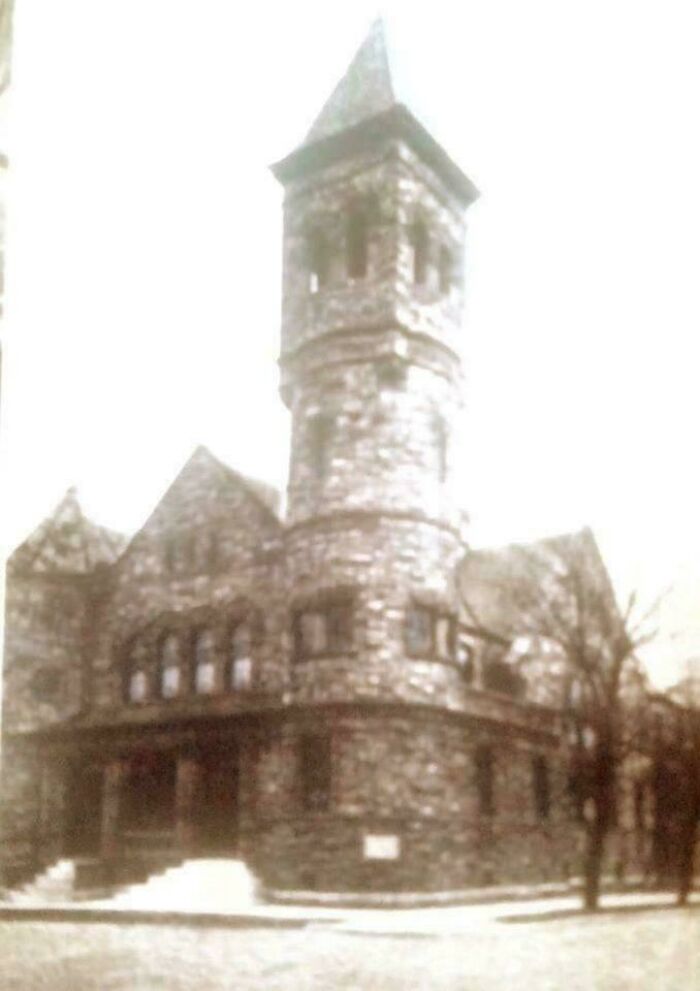 Stone building with a tall tower and gothic style, giving off supervillain headquarters evil aura vibes.