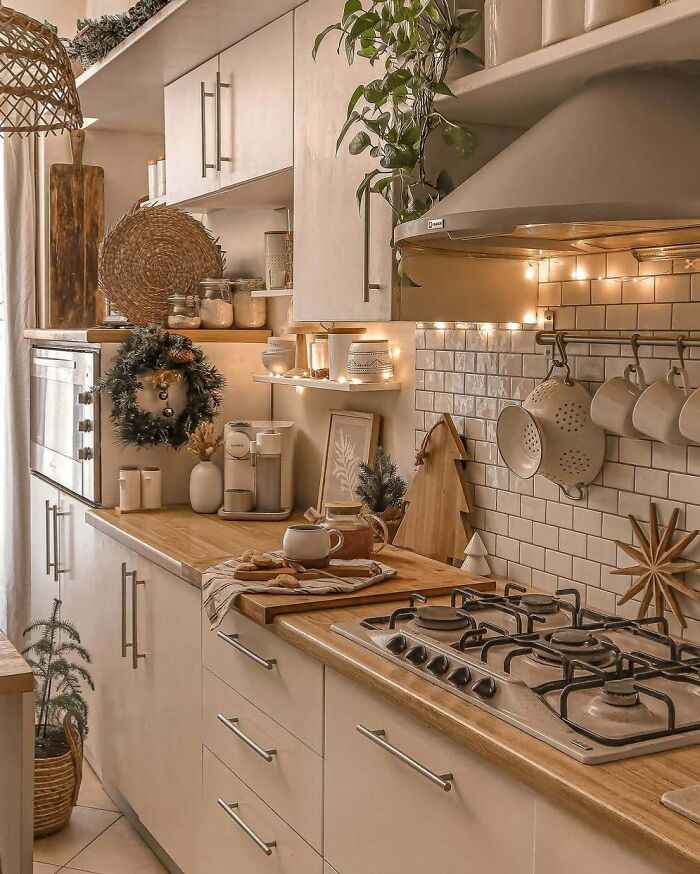 Cozy kitchen with Christmas-decorating ideas, featuring garland, wreath, and fairy lights for a festive atmosphere.