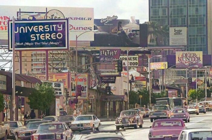 1970s West Coast street scene with vintage cars and colorful billboards, capturing iconic era vibes and retro charm.