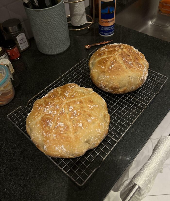 Two freshly baked, golden bread loaves on a cooling rack, evoking a wholesome Christmas vibe in a cozy kitchen setting.