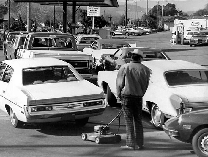 Traffic jam in 1973, depicting a man with a lawn mower amidst vintage cars.