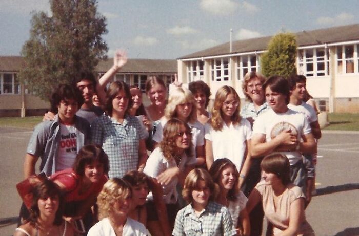 '70s high school students posing outside in front of school buildings, showcasing retro fashion and hairstyles.