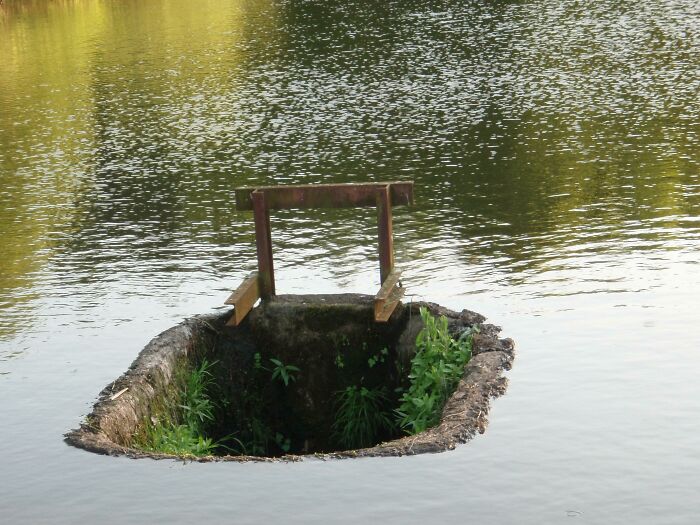 Concrete slab surrounded by grass appears like a bad render in the middle of a lake.