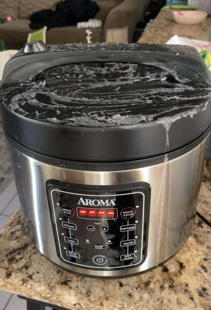 Rice cooker with overflowed contents on counter, highlighting infuriating family members' kitchen mishap.