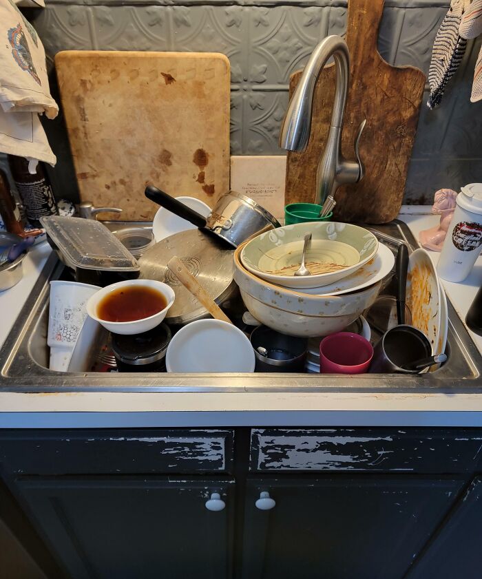 Overflowing sink filled with dirty dishes, a classic sign of infuriating family members.