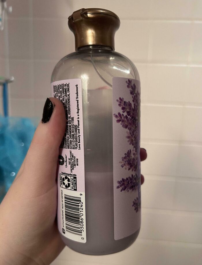 Hand holding a partially used lotion bottle, with a lavender label, related to infuriating family members.