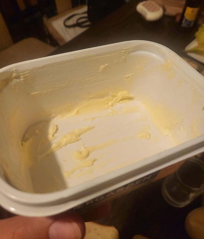 Empty butter container causing frustration at the dinner table, exemplifying infuriating family members' habits.
