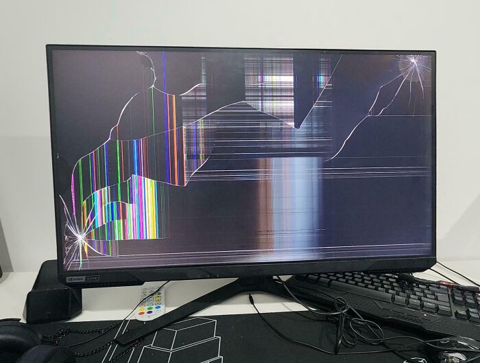Broken monitor on a desk, screen c*****d likely due to infuriating family members.