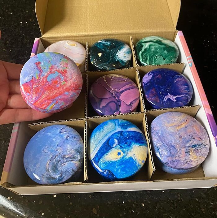 Colorful round soaps in a subscription box featuring swirled patterns and vibrant hues.