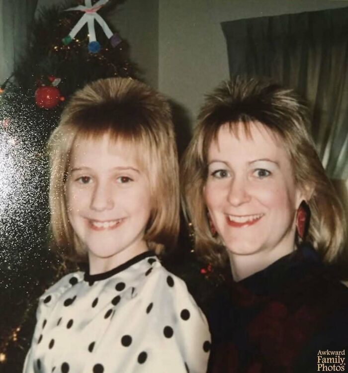 Mother and daughter pose with smiles and unique hairstyles in this awkward family photo.