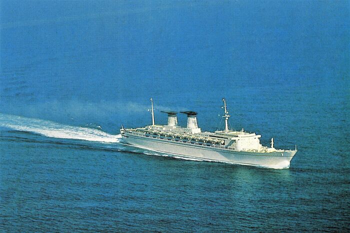 Aerial view of a 1973 ocean liner cruising through calm blue waters.