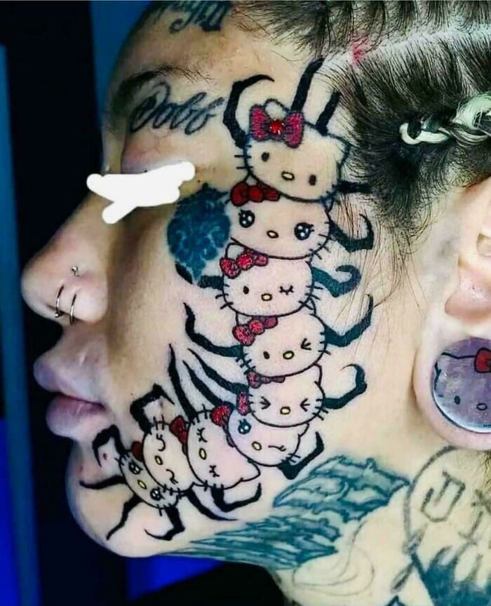 Close-up of a unique Hello Kitty centipede tattoo on a person's face.