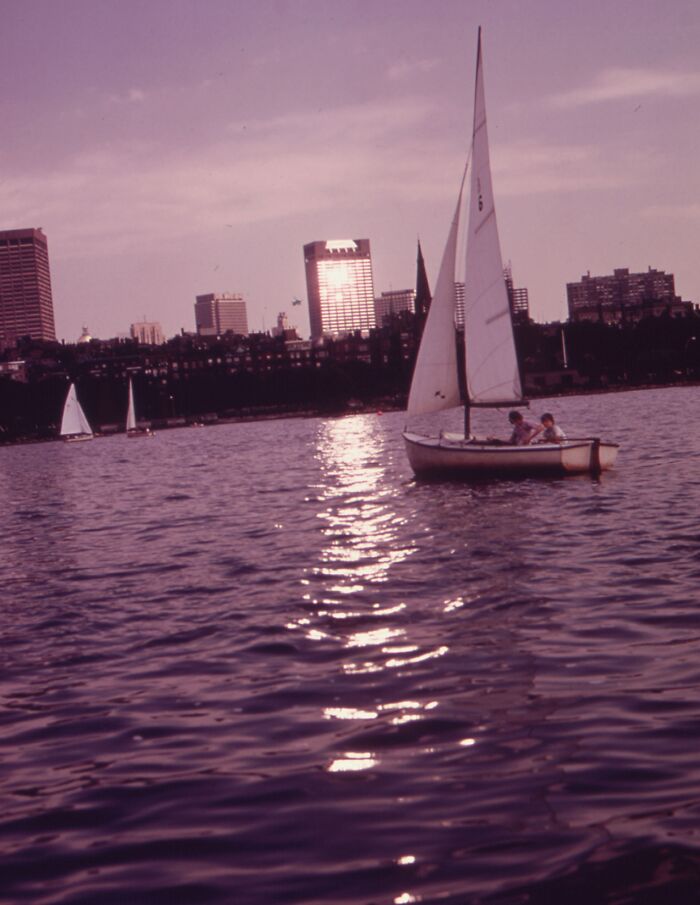 Sailboat on water with city skyline in the background, reflecting 1973 world in pictures.