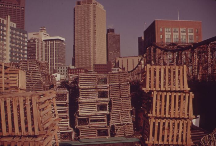 Skyline of 1973 city with stacked wooden crates and tall buildings, capturing historical urban architecture.