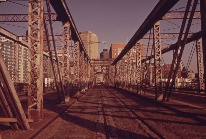 Iron bridge from 1973 overlooking a cityscape, illustrating urban architecture of the era.