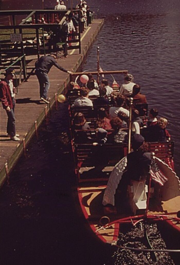 1973 scenic view of a boat with passengers at a dock, capturing a nostalgic moment on water during the year.