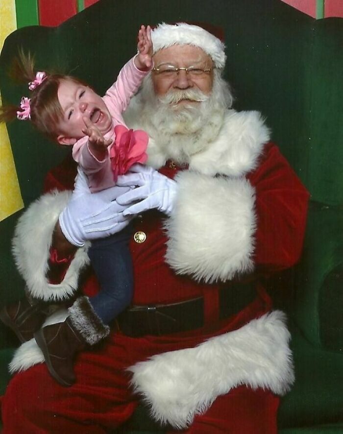 Crying child held by Santa in a classic "Creepy-Santas" photo setting.