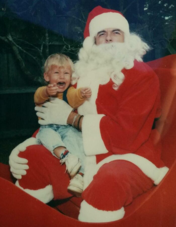 A frightened child sits on a scary-looking Santa's lap, embodying the theme of Creepy Santas.