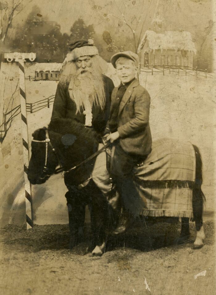 Vintage photo of a creepy Santa with a boy on a pony in a winter scene.