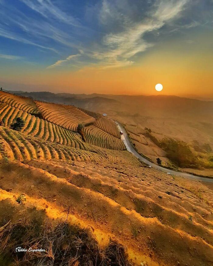 Indonesian photographer captures stunning sunset over terraced fields, illustrating simple life moments.