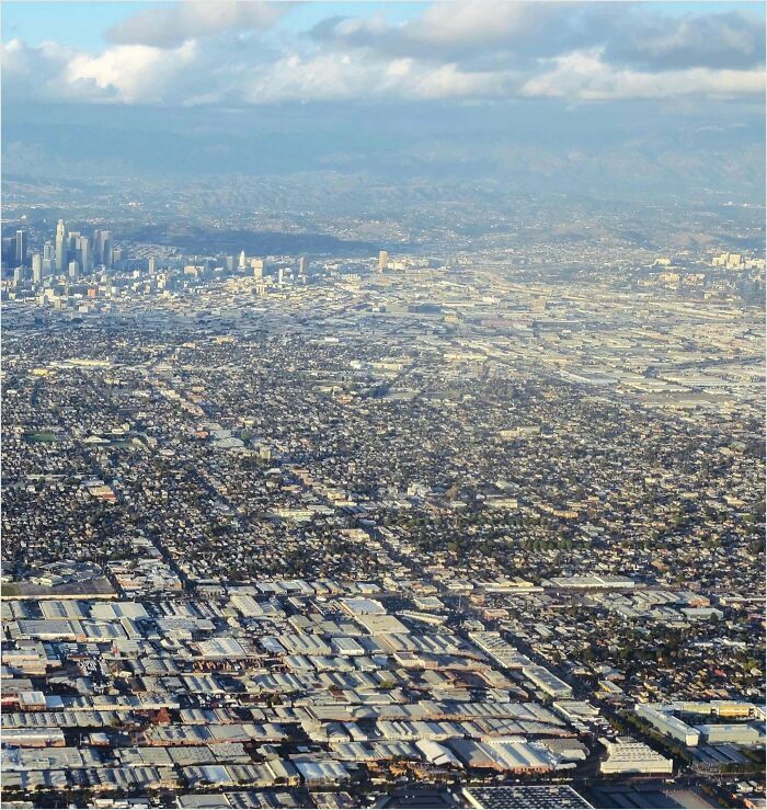 Aerial view of a sprawling urban area, highlighting densely packed buildings and industrial sections.