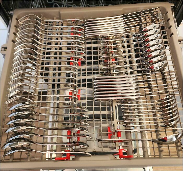 Perfectly arranged silverware in a dishwasher tray demonstrating a satisfying perfect fit.