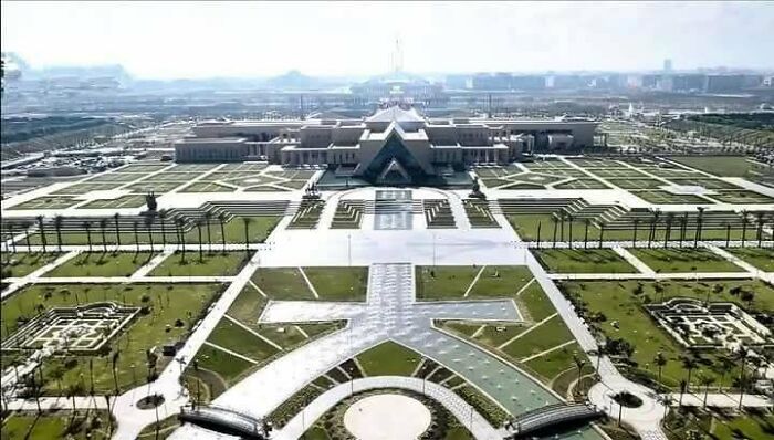 Vast urban landscape featuring symmetrical concrete and green patterns, resembling an unreal cityscape in an urban hell theme.