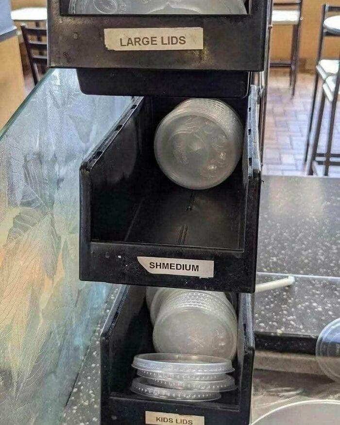 Weirdness in lid sizes labeled large, shmedium, and kids at a drink station.