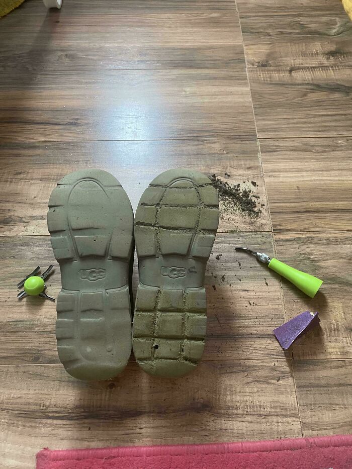 Worn shoe soles on wooden floor, tools nearby, echoing a rejection of consumerism.