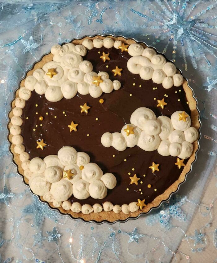 Chocolate pie with clouds and stars decoration showcasing a baker's next-level culinary skills.