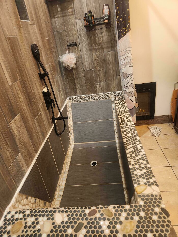 Bathtub with uneven tile design and unusual shape in a bathroom, showcasing a DIY disaster home improvement mistake.