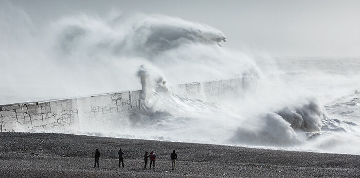 Majestic waves crashing over a sea wall, captured in a mesmerizing photograph.
