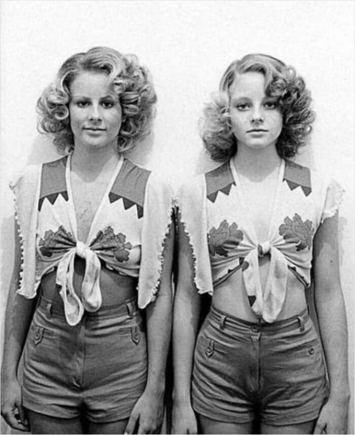 Two women in vintage outfits with curled hair, likely from history not seen in textbooks.