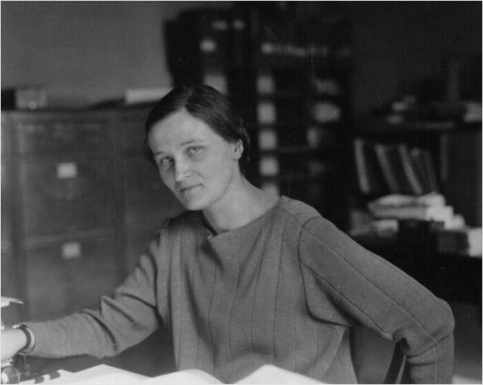 Woman at a desk, possibly involved in a historic event or discovery.
