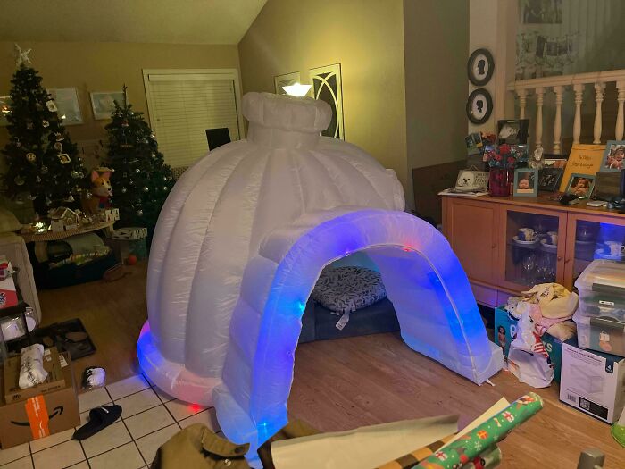 Inflatable igloo with colorful lights in a cozy living room, showcasing the rewarding job of being a dad.