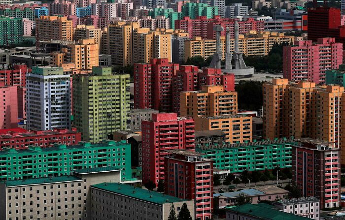 Colorful high-rise buildings in a densely packed urban area depicting urban hell.
