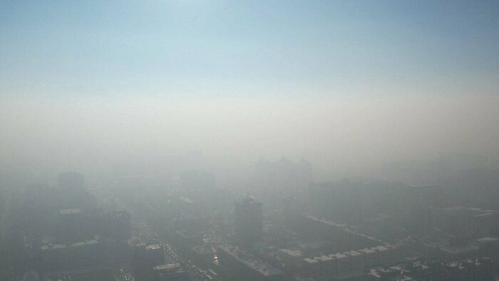 A cityscape shrouded in heavy smog, creating an urban hell-like environment.