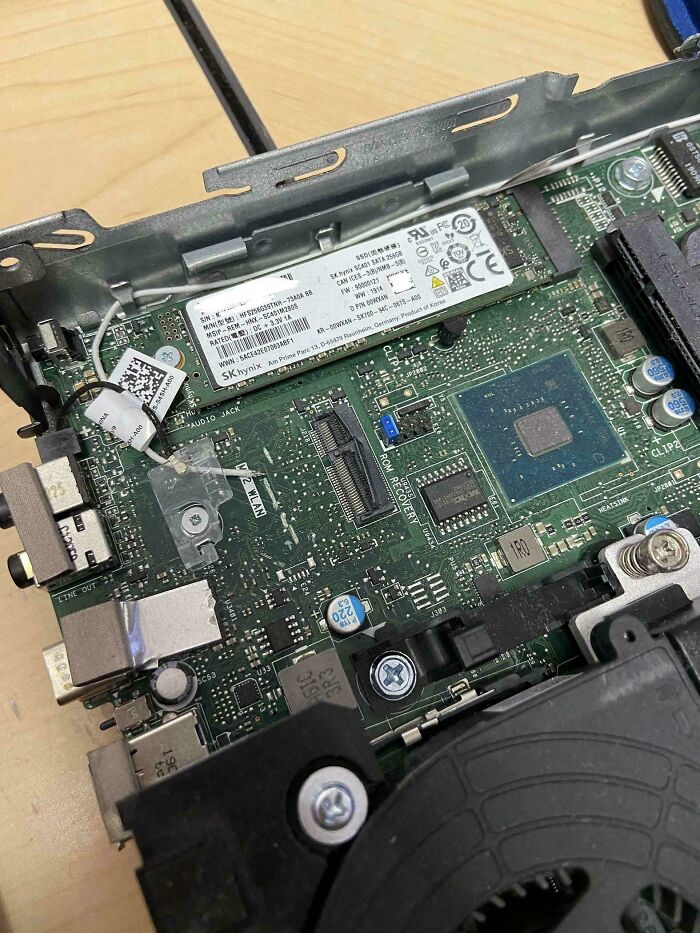 Close-up of a computer motherboard with tech support components exposed during hardware troubleshooting.