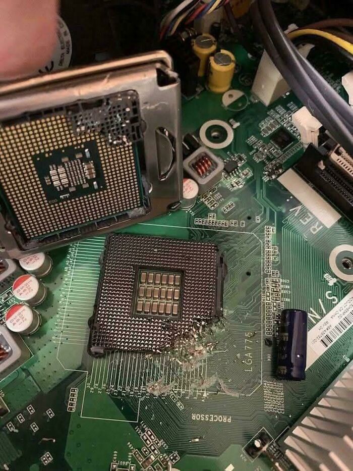 Damaged CPU socket on a computer motherboard illustrating tech support workers wishing they had chosen a different profession.
