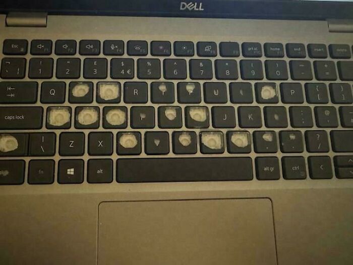 Laptop keyboard with many missing keycaps showing worn out keys, reflecting tech support work frustrations.