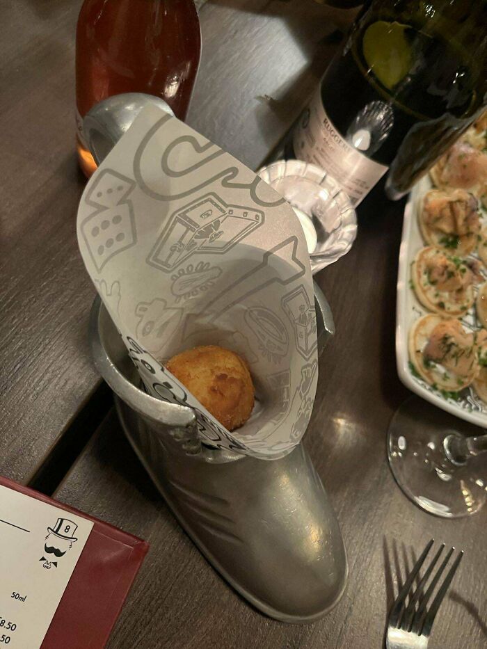Fried snack served inside a metal boot with paper lining, showcasing one of the most ridiculous ways food is served in restaurants.