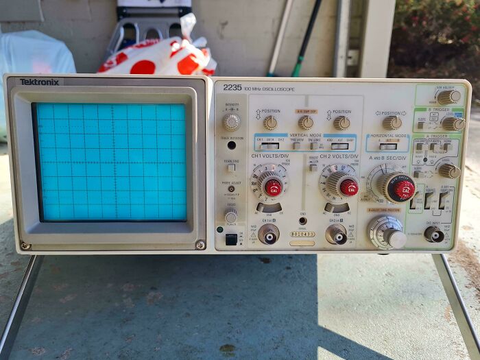 Vintage oscilloscope found while dumpster diving, potential value of $550, showcasing dials and screen in sunlight.